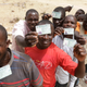 People displace by Islamist militants display their voters card